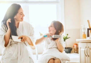Daughter and mother brushing their hair