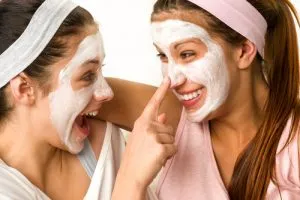 Playful teens wearing a purifying mask for acne-prone skin